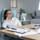 Female office worker procrastinating at her desk looking disengaged