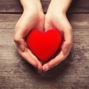 Two hands holding a felt heart signalling empathy